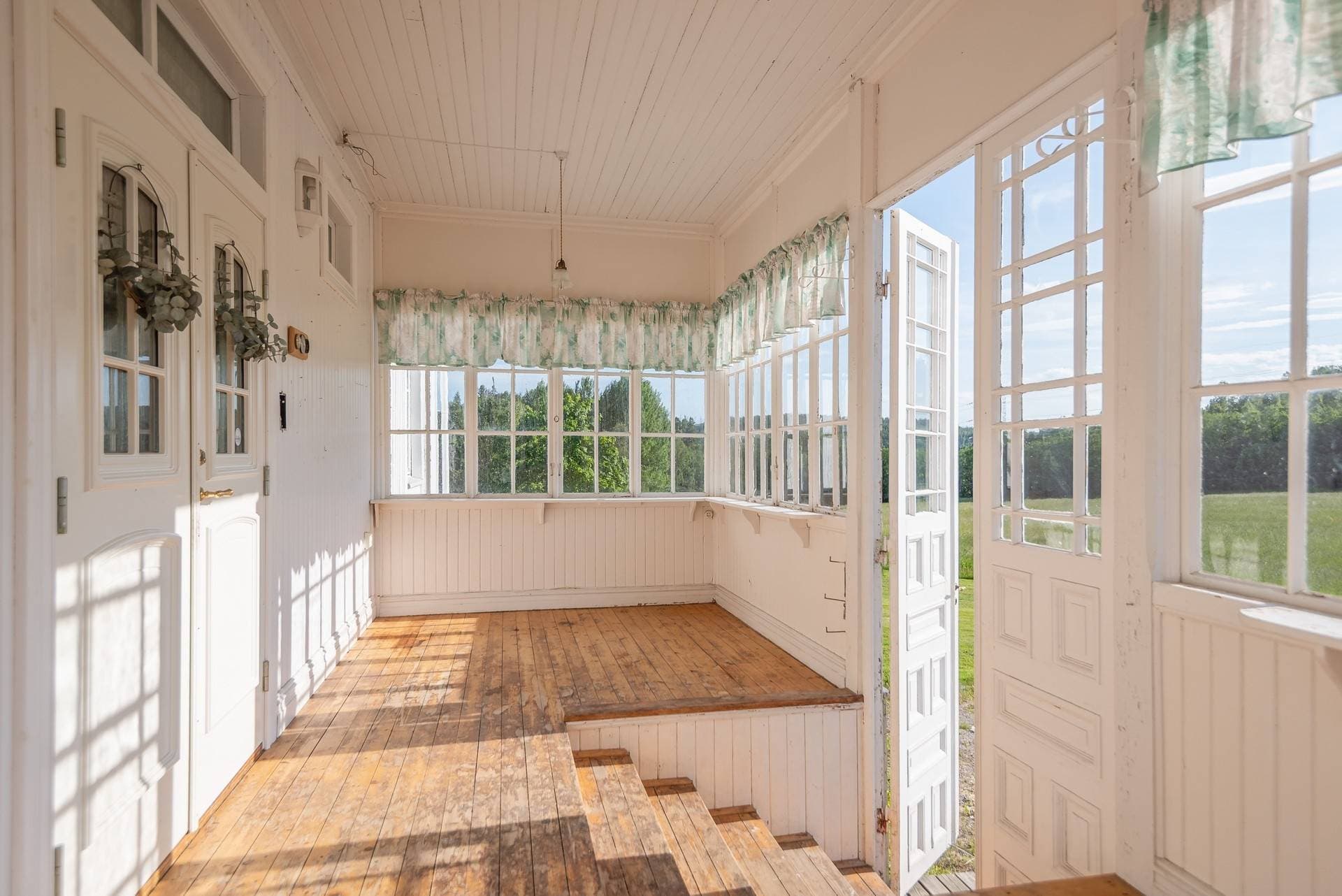 Glasveranda med vy mot övre bostadshus.