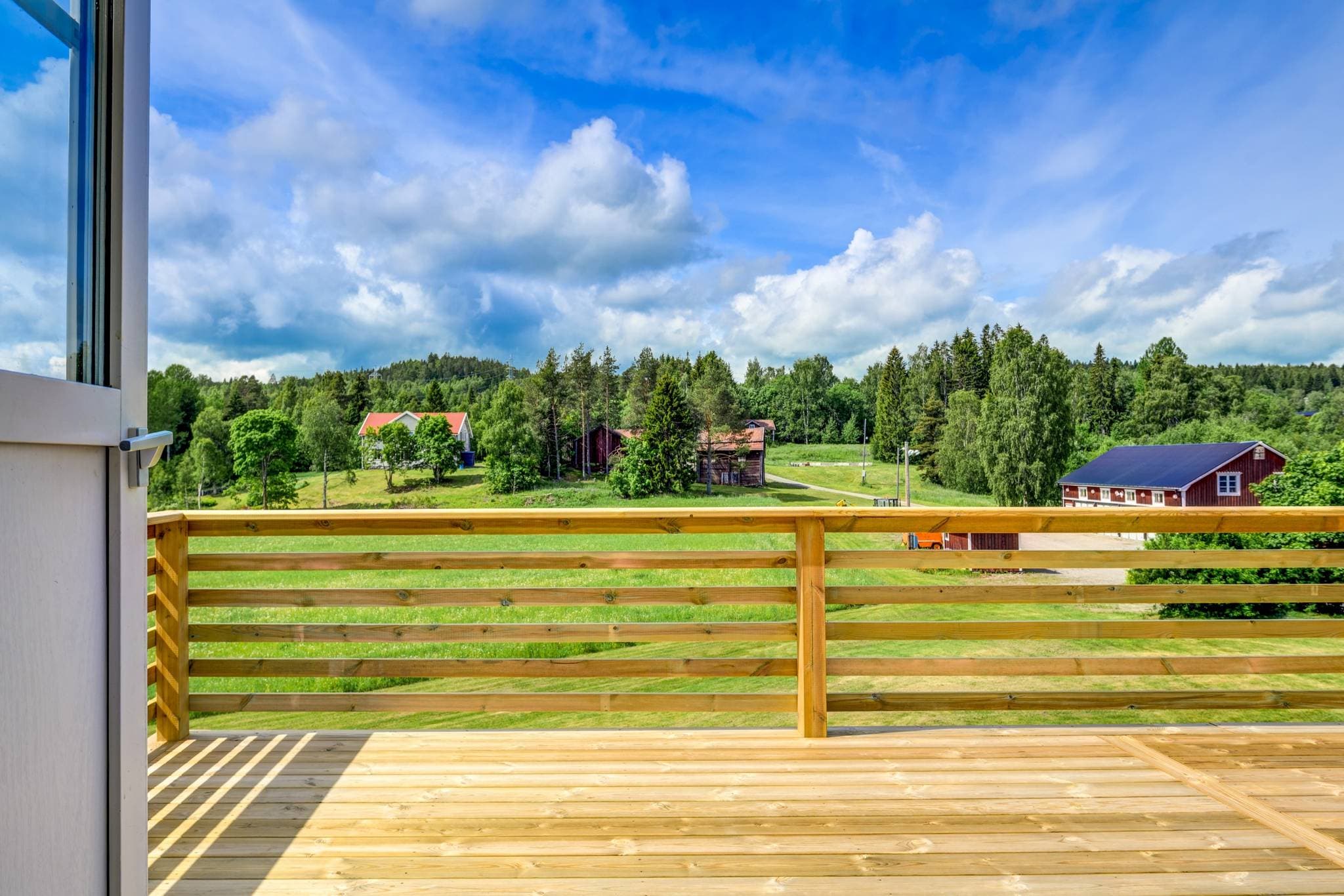 Vy från balkong över åker och övre bostadshus.