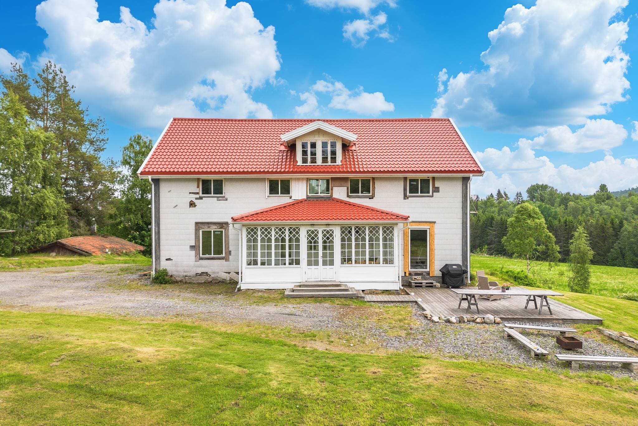 Övre bostadshus mot en stor gräsmatta riktning väster.
