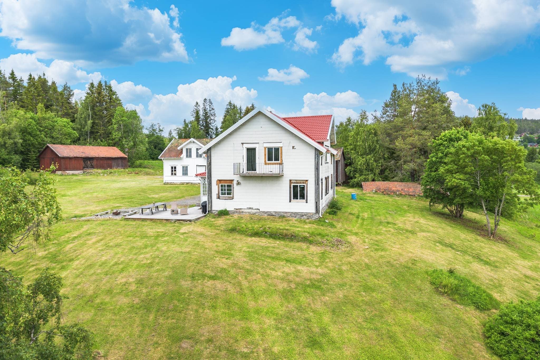 Övre bostadshus med utsikt över gräsmatta och åkermark, riktning syd.