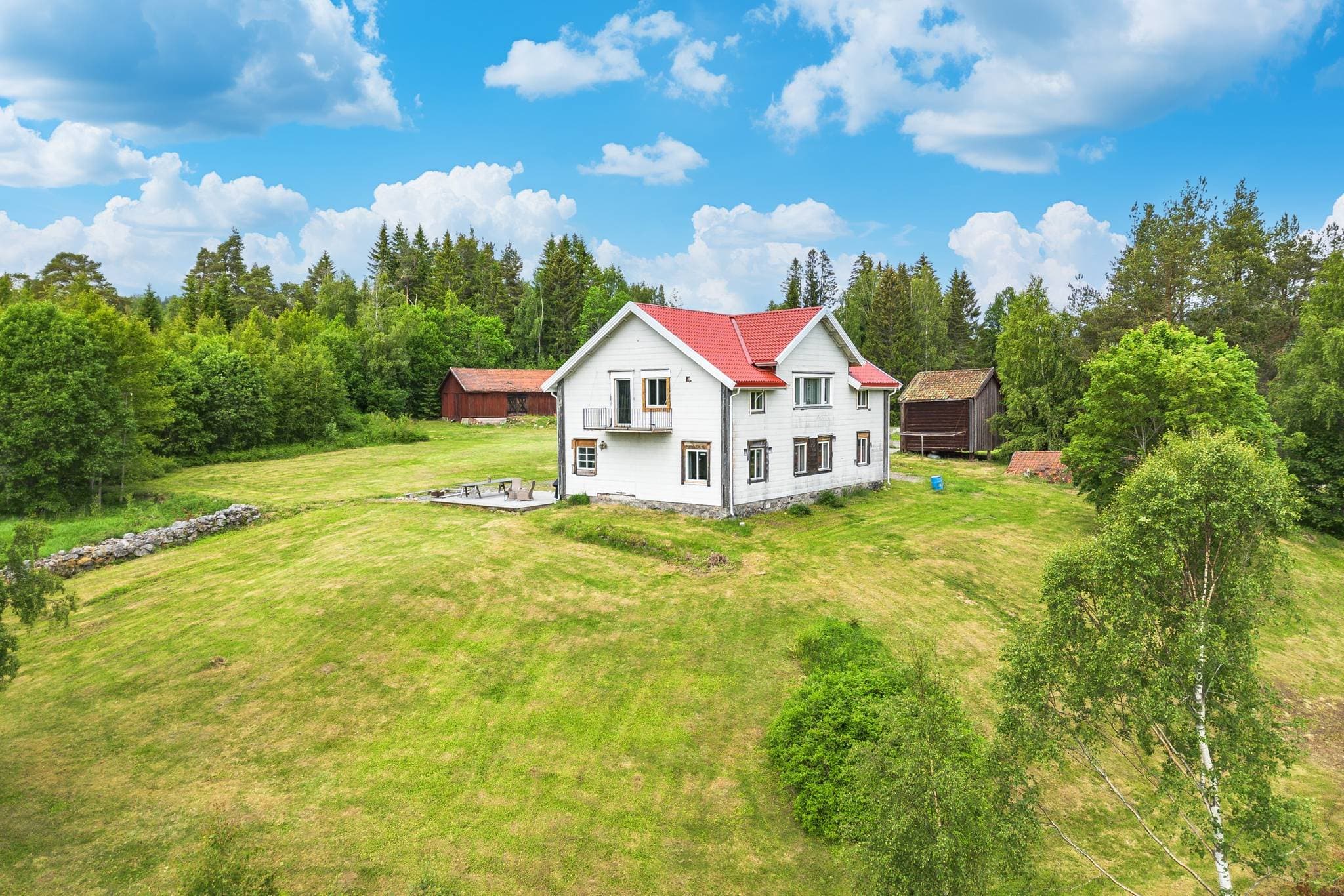 Övre bostadshus med utsikt över gräsmatta och åkermark, riktning syd.